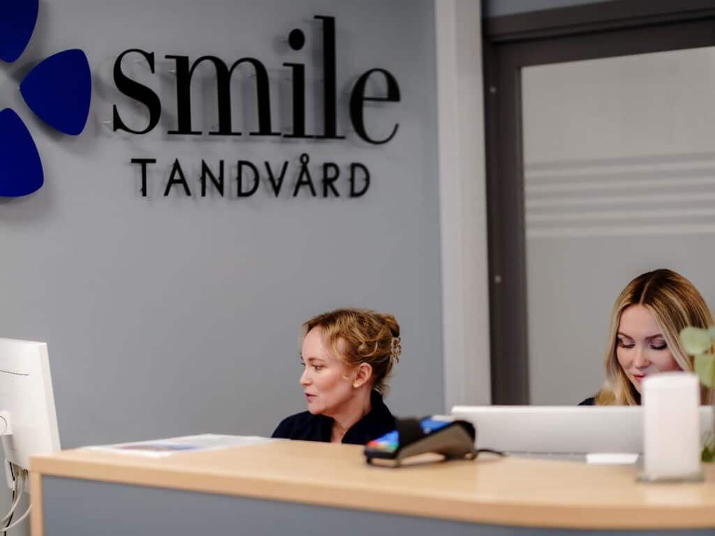 Reception på Smile Tandvård Hagastaden, Vasastan, med Smile-logotyp i bakgrunden.