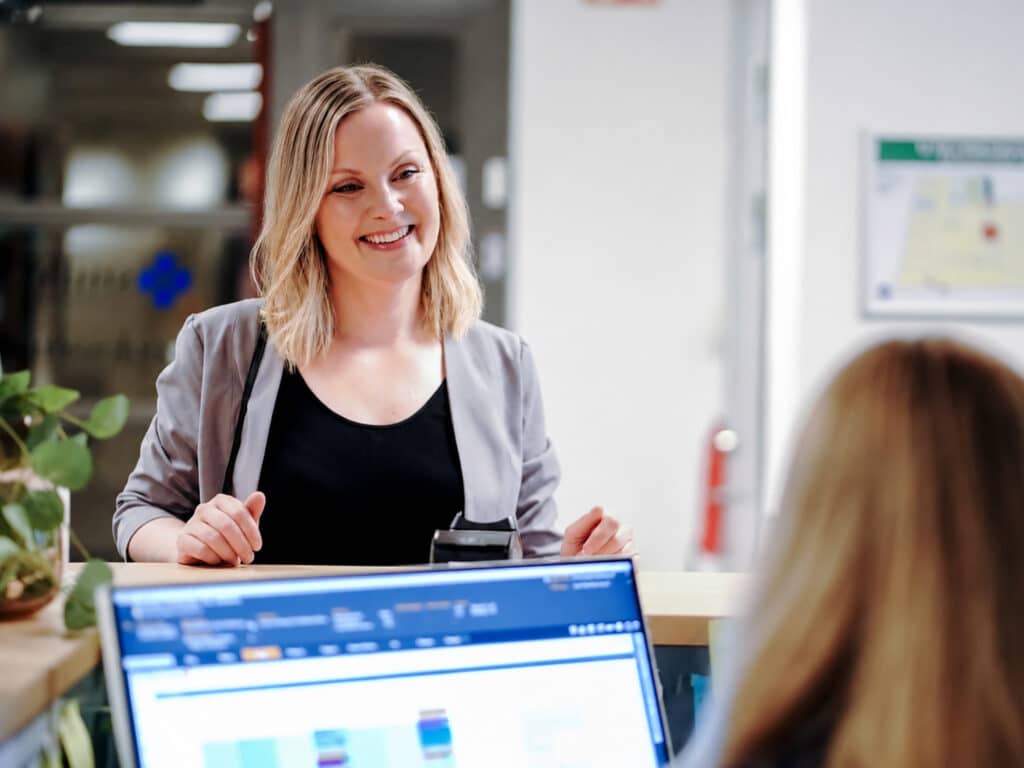 Medarbetare på Smile Tandvård Hagastaden, Vasastan, välkomnar en patient i receptionen.