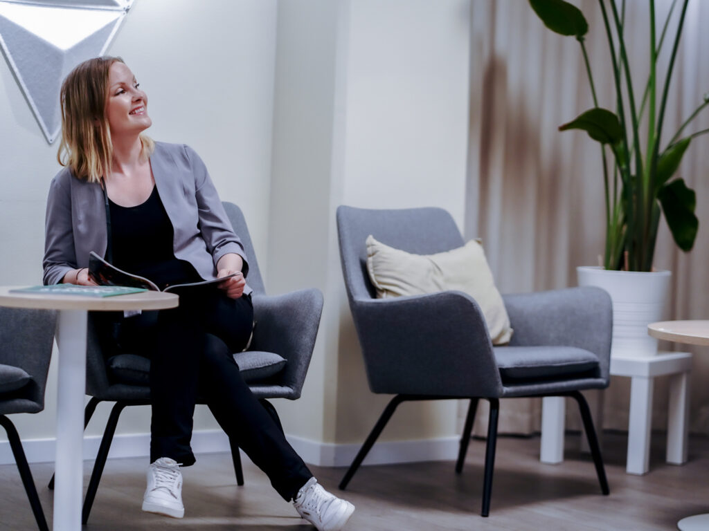 Patient sitter i väntrummet på Smile Tandvård Hagastaden i Stockholm inför tandläkarbesök.