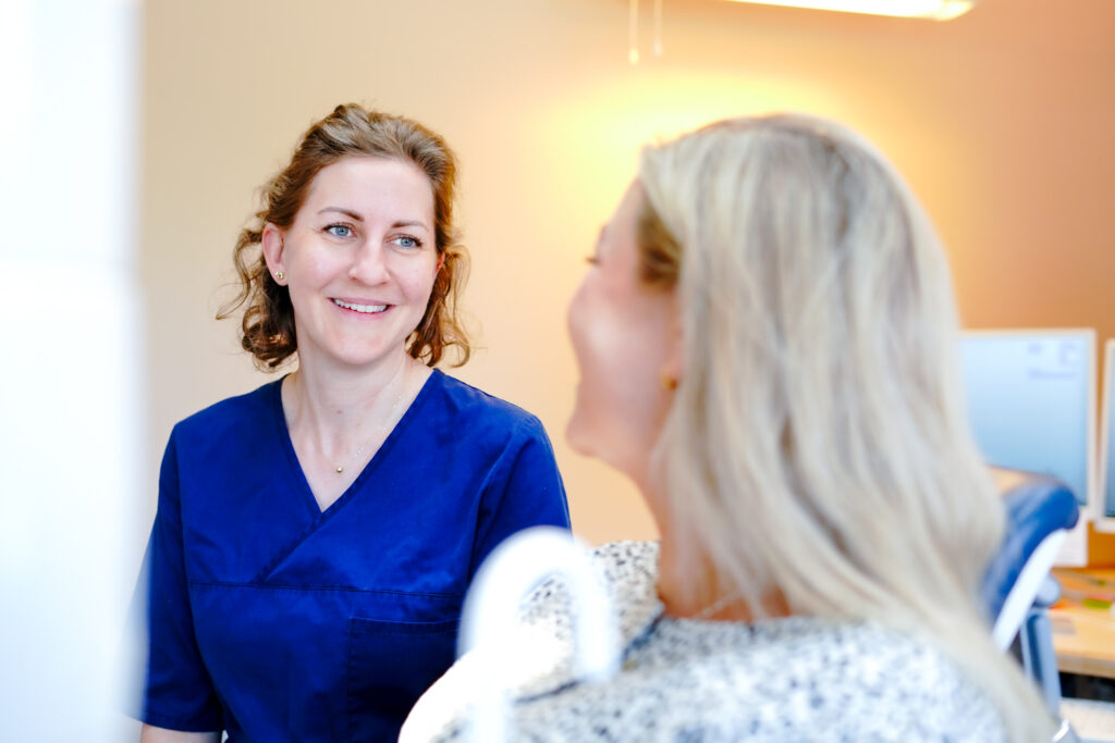 Tandläkare och patient under konsultation på kliniken i Täby