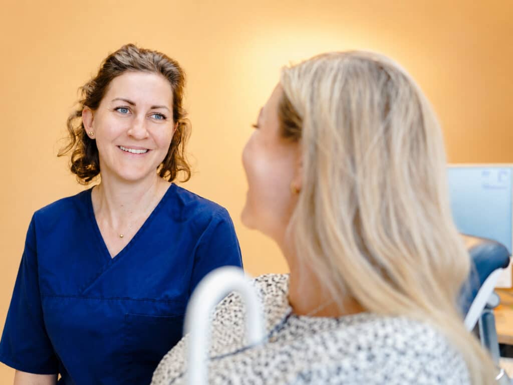 Tandläkare och patient under konsultation på kliniken i Täby.
