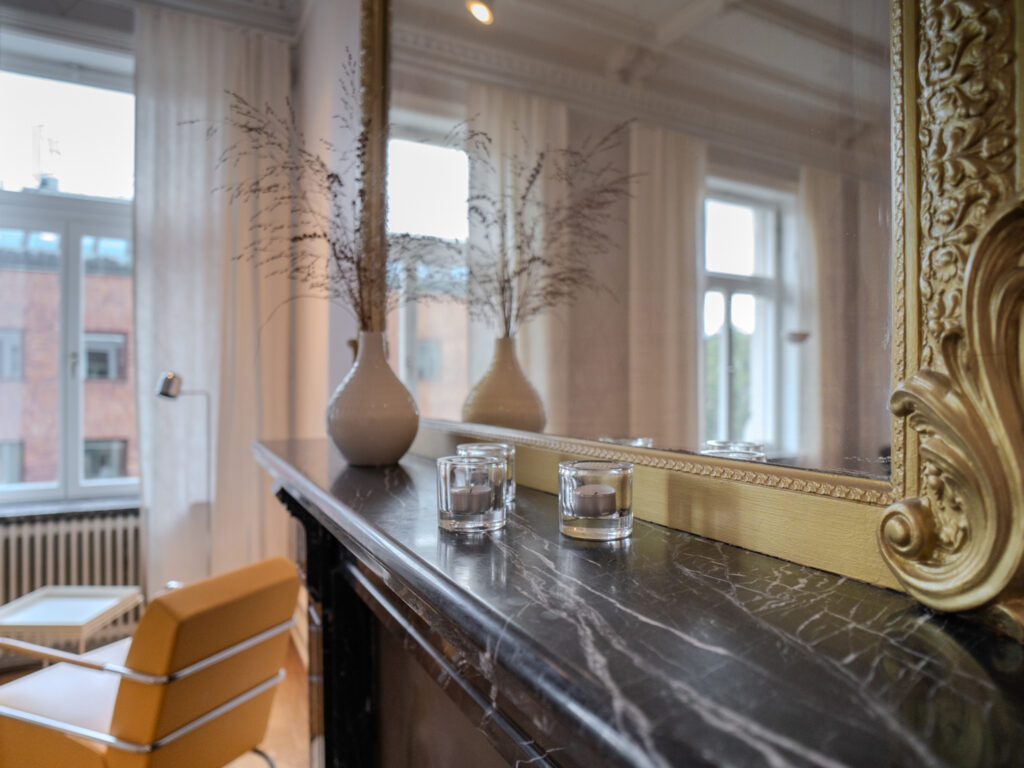 Elegant inredning på Smile Tandvård Göteborg med en marmorerad bänkskiva, stora fönster och dekorativa vaser.