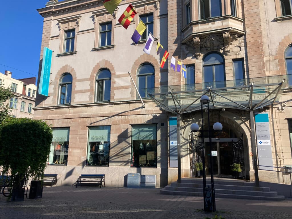 Exteriör av Smile Tandvård-kliniken i Karlskrona, med en välkomnande entré och sittplatser utanför byggnaden.