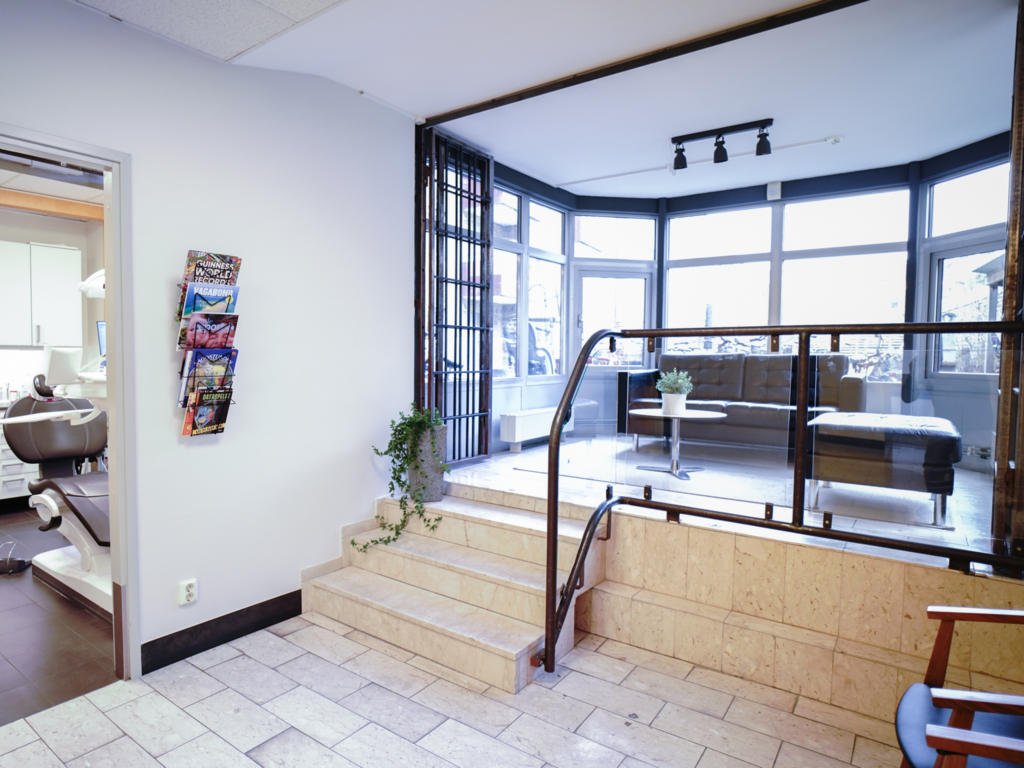 Interiör på Smile Tandvård Malmö City – Rymligt och modernt väntrum med eleganta möbler och en ljus inredning för en trivsam upplevelse.