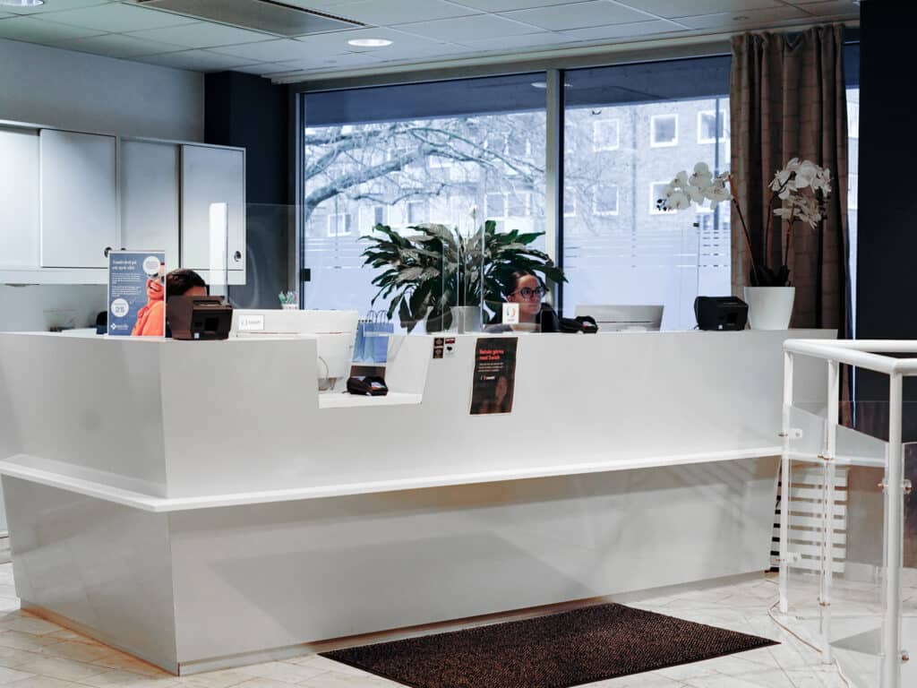 Reception och väntrum – Ljus och inbjudande reception med stora fönster och sittplatser för besökare.