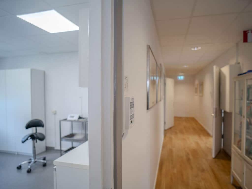 Ljus korridor på Smile Tandvård Molkom med vita väggar och behandlingsrum på sidorna.