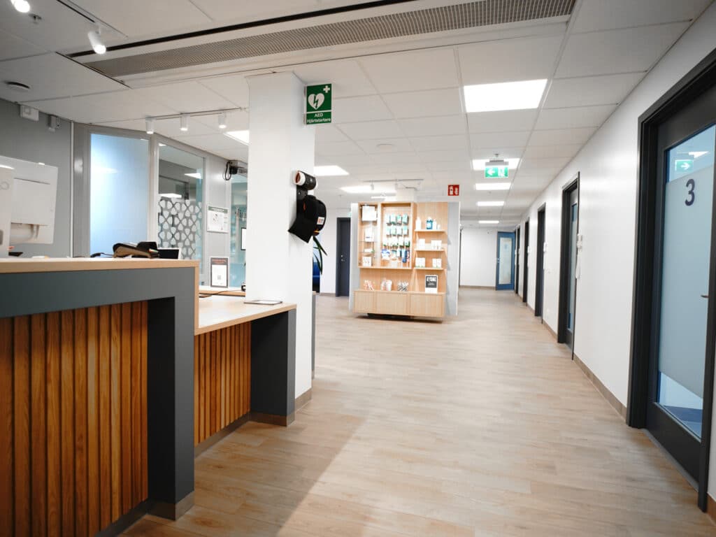 Ljus och öppen korridor hos Smile Tandvård med trädetaljer och moderna inredningselement.