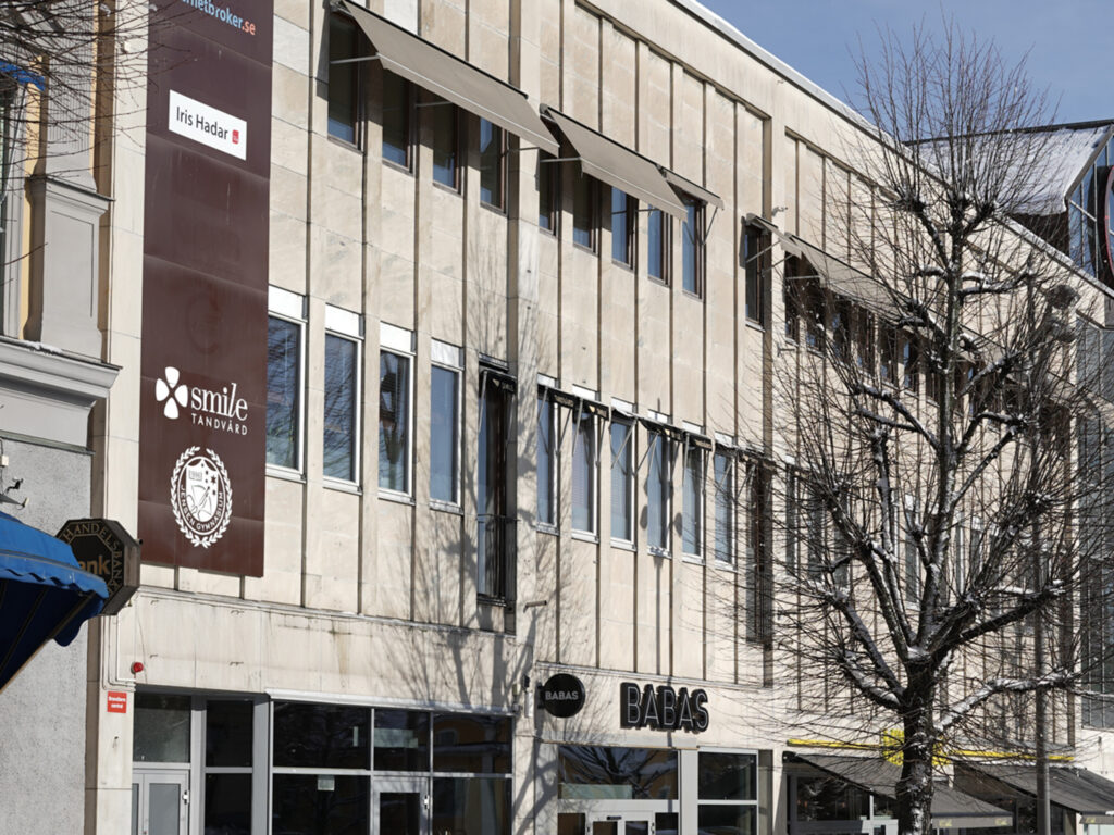Fasad av Smile Tandvård Örebro Stortorget, en modern byggnad med klinikens logotyp.