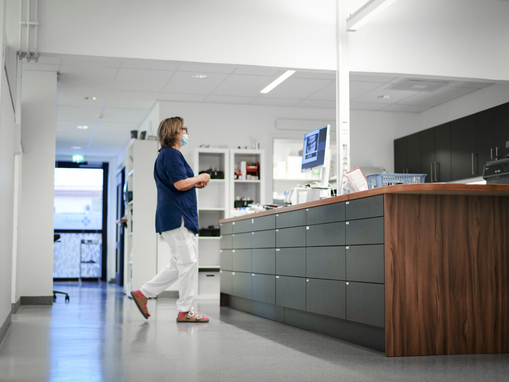 Receptionist vid disken på Smile Tandvård Piteå, redo att hjälpa patienter.