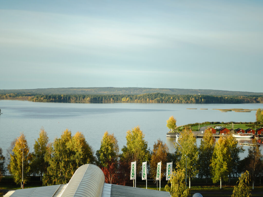 Utsikt över Piteå med vatten och höstfärgade träd, nära Smile Tandvård Piteå.