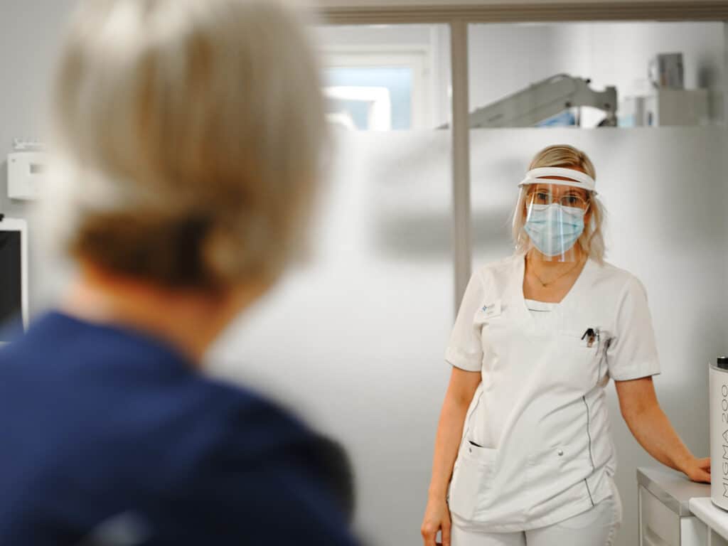 Tandvårdspersonal på Smile Tandvård Umeå med ansiktsvisir för att säkerställa patientsäkerhet.