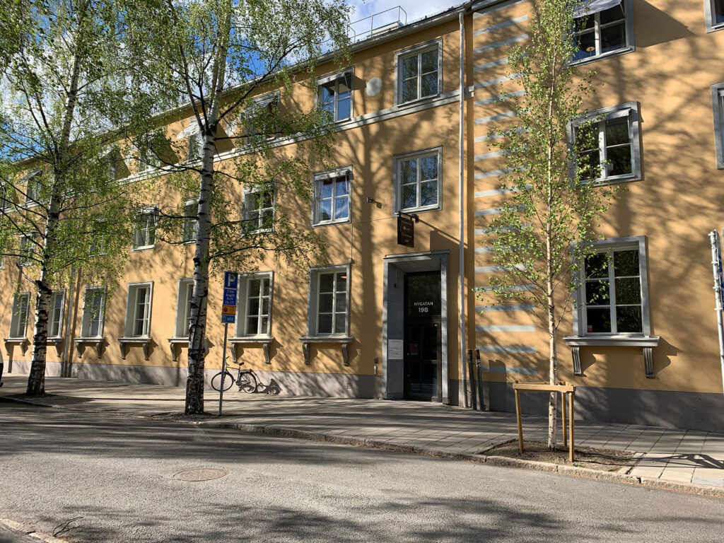 Exteriör av Smile Tandvård Umeå, belägen i en historisk byggnad med träd utanför.