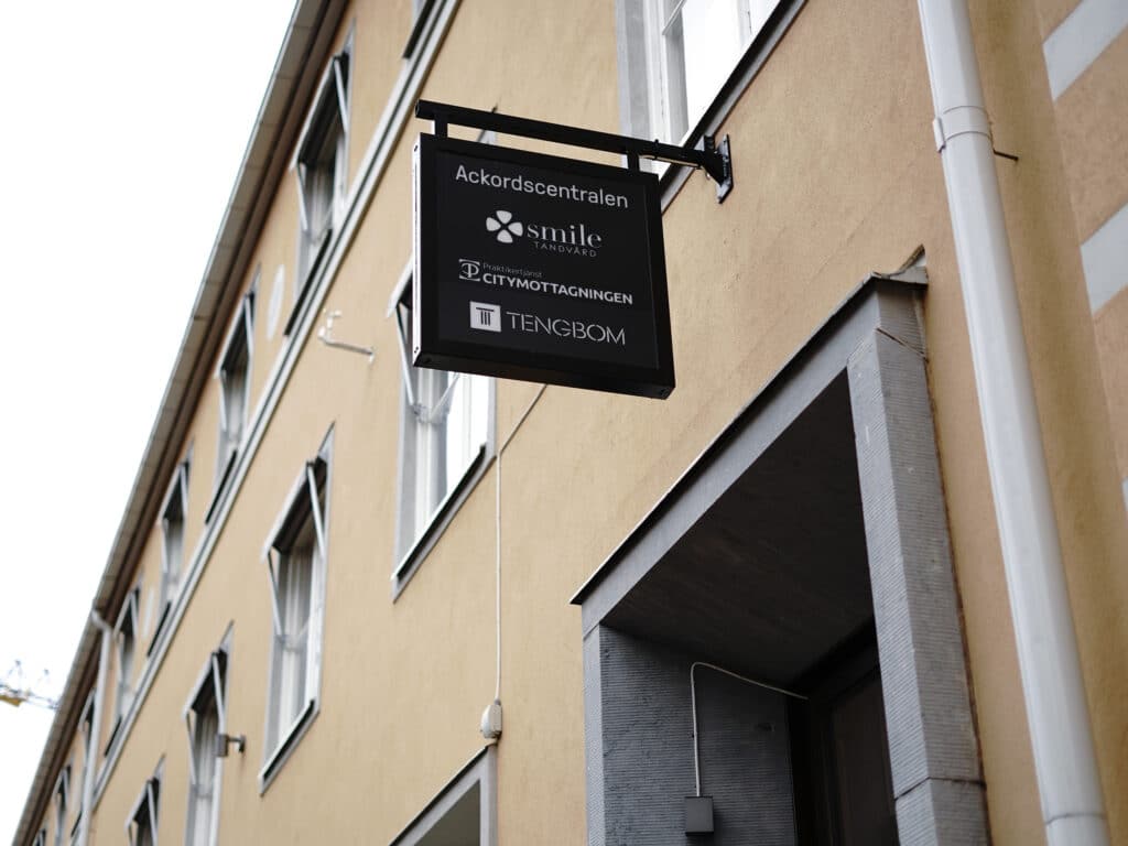 Skylt utanför Smile Tandvård Umeå som visar klinikens namn och adress.