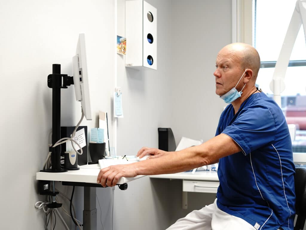 Tandläkare vid arbetsstation hos Smile Tandvård Umeå, redo för nästa patient.
