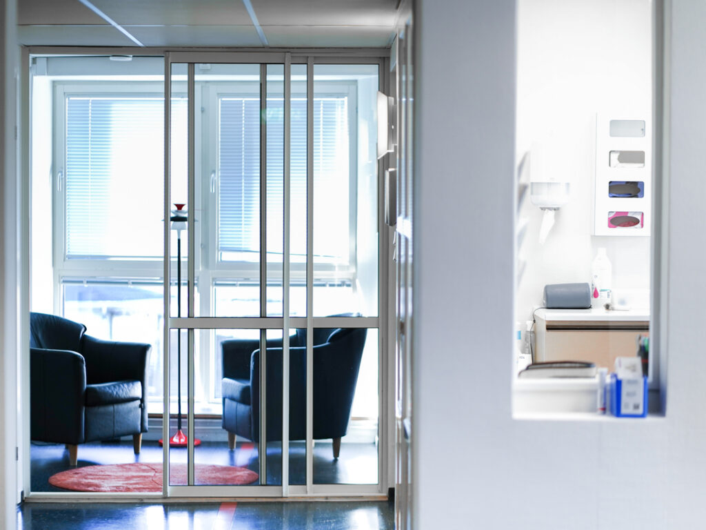 Modern och ljus korridor med inblick till behandlingsrum på Smile Tranås.