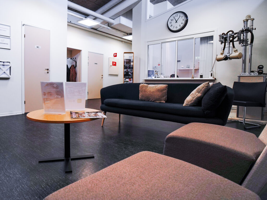 Väntrum hos Smile Tandvård i Tranås – en modern och välkomnande miljö med soffor, informationsmaterial och reception i bakgrunden.