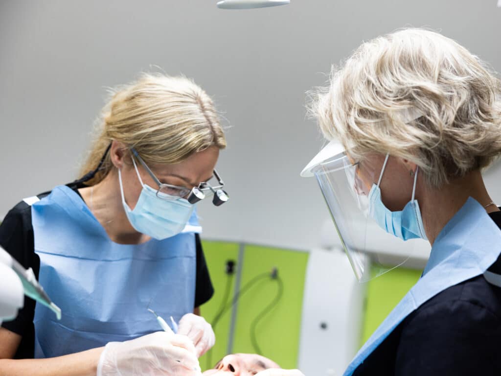 Tandläkare och tandsköterska utför en tandbehandling på en patient på Smile Varberg.